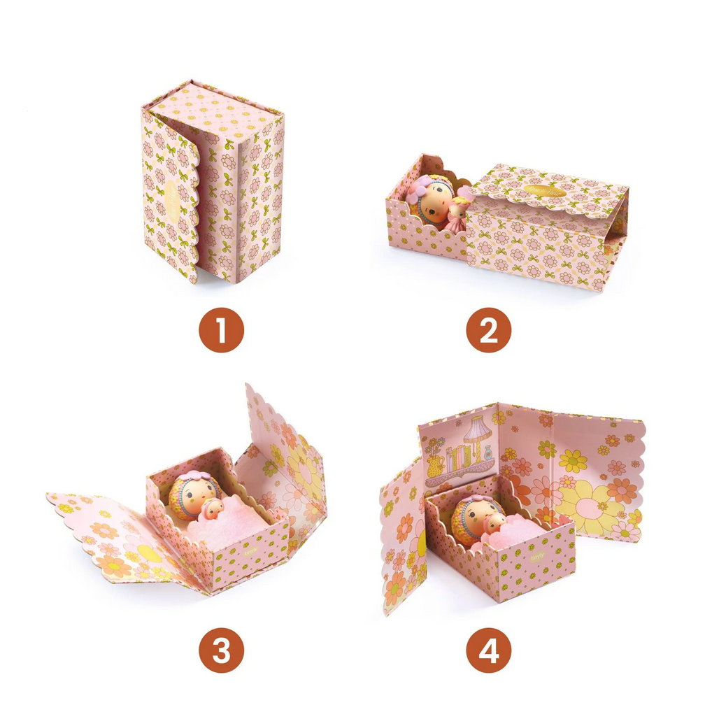 Product display of a toy box with a baby doll inside, featuring the Djeco brand.