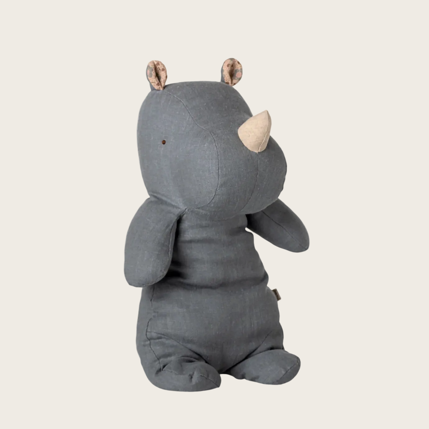 Gray rhinoceros plush toy on a beige background with product details overlay.