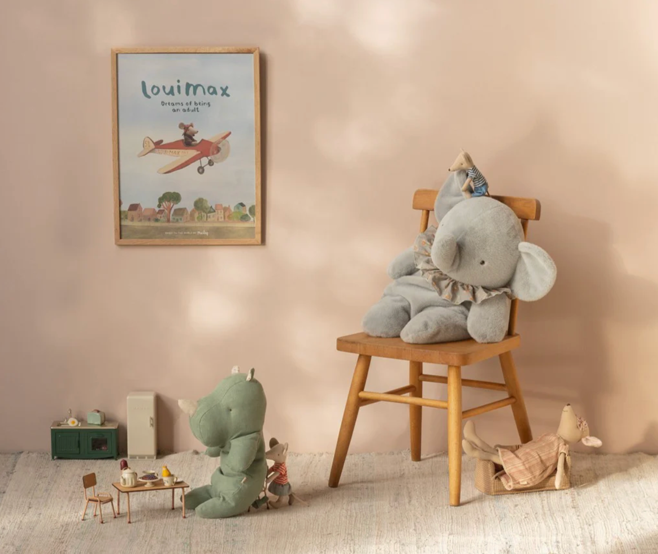 Children's room with plush toys on a chair and floor, featuring a 'louimax' poster on the wall.