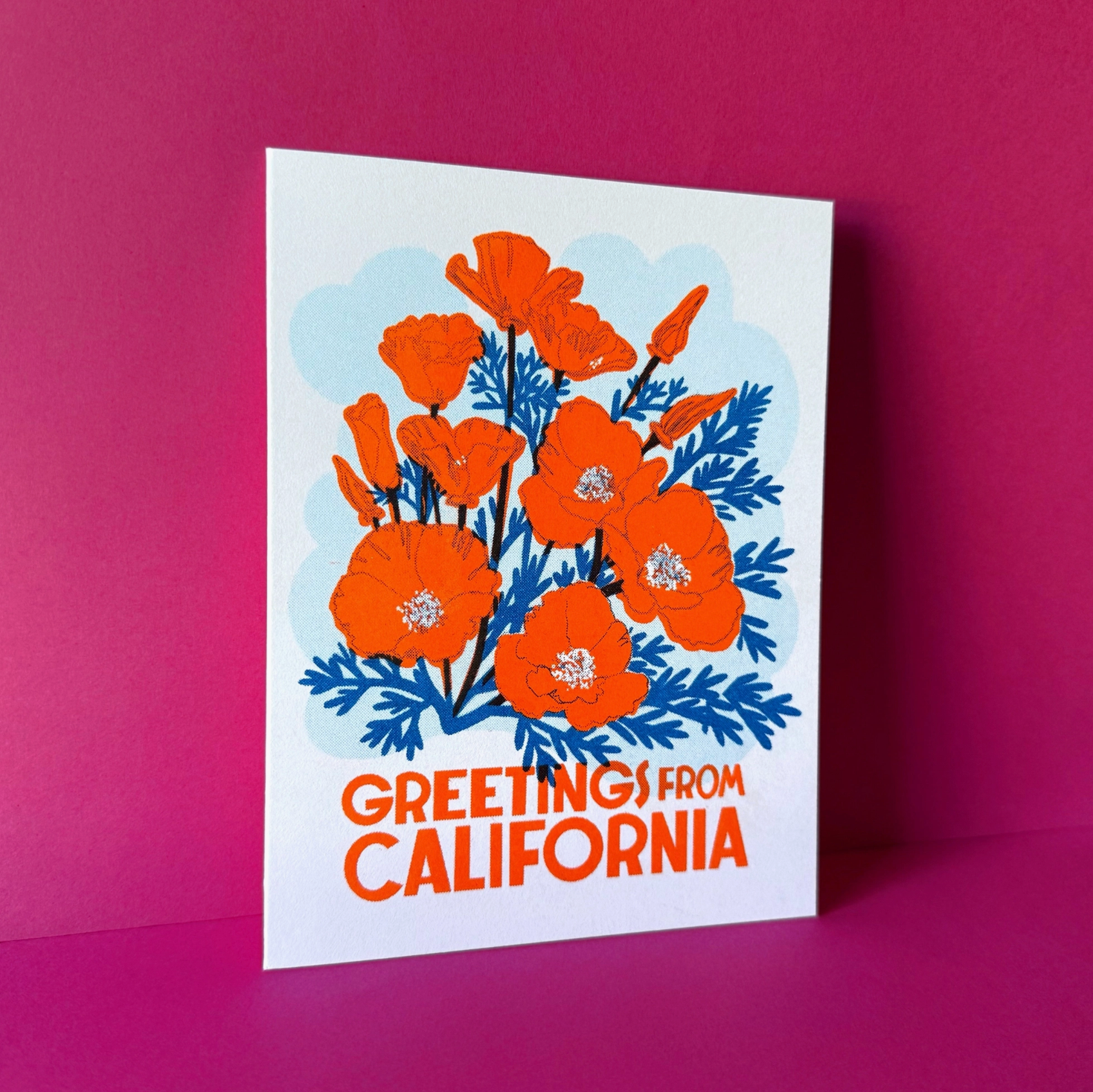 Card with orange flowers and 'Greetings from California' text on a pink background
