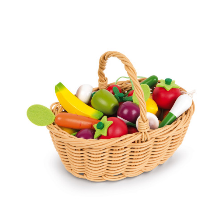 Wicker basket with toy fruits and vegetables on a white background