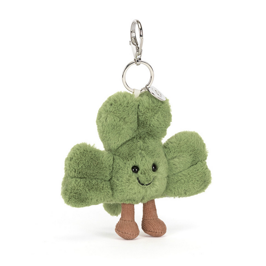 Green shamrock-shaped bag charm with a smiling face on a white background