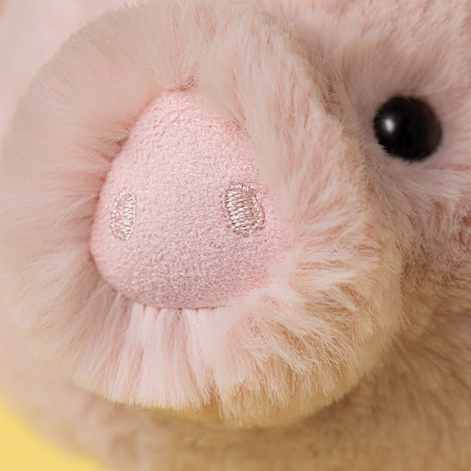 Close-up of a plush toy with a pink nose and black eye.