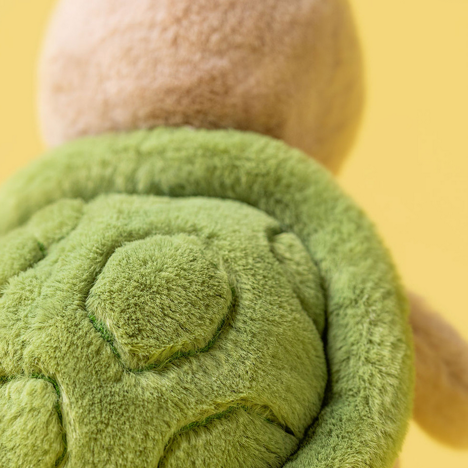 Close-up of a green plush toy with a yellow background