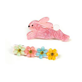 Pink hair tie with bunny design and three colorful flower clips on a white background