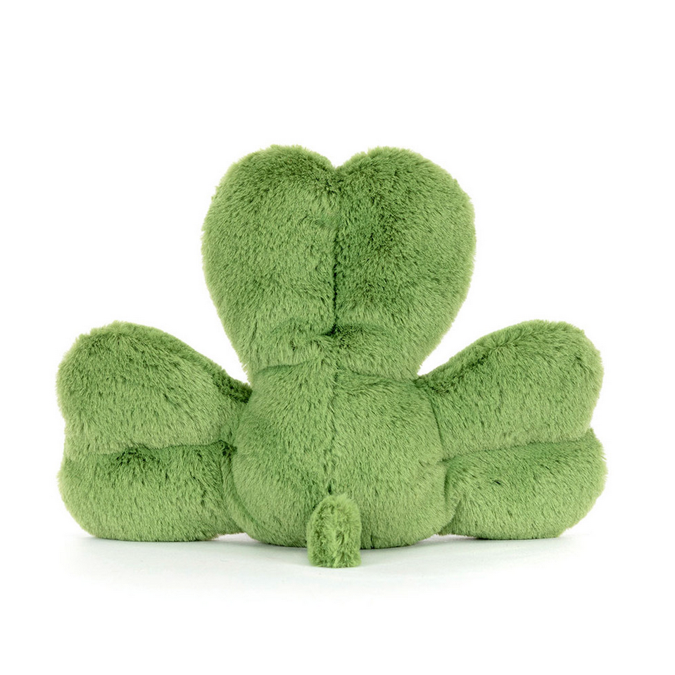 Green plush toy shaped like a clover leaf on a white background