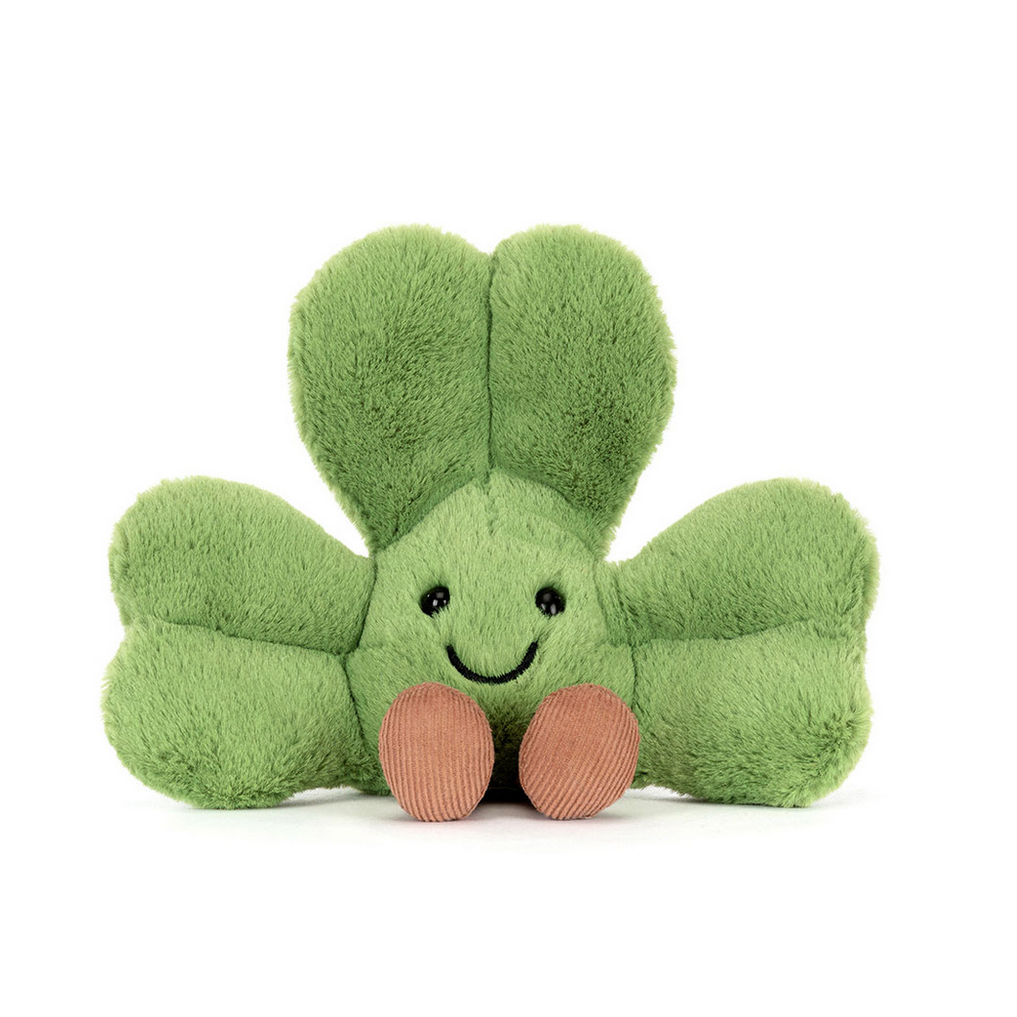 Green shamrock-shaped plush toy with a smiling face on a white background