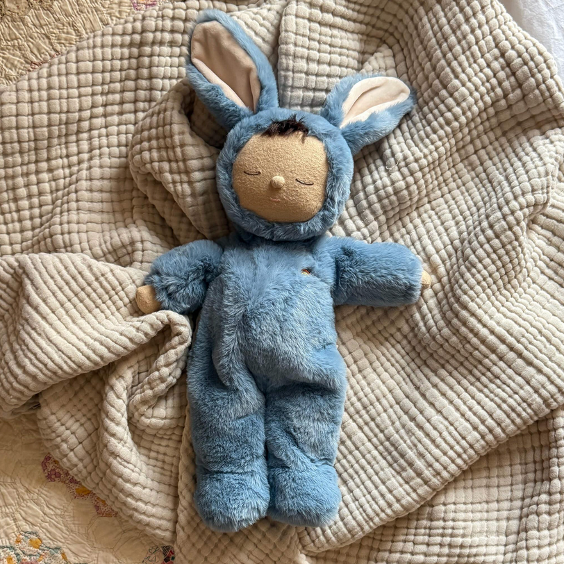 Blue plush toy with bunny ears on a textured beige blanket