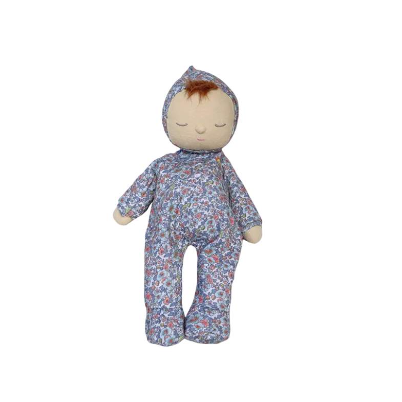 Stuffed toy baby in a floral outfit on a beige background