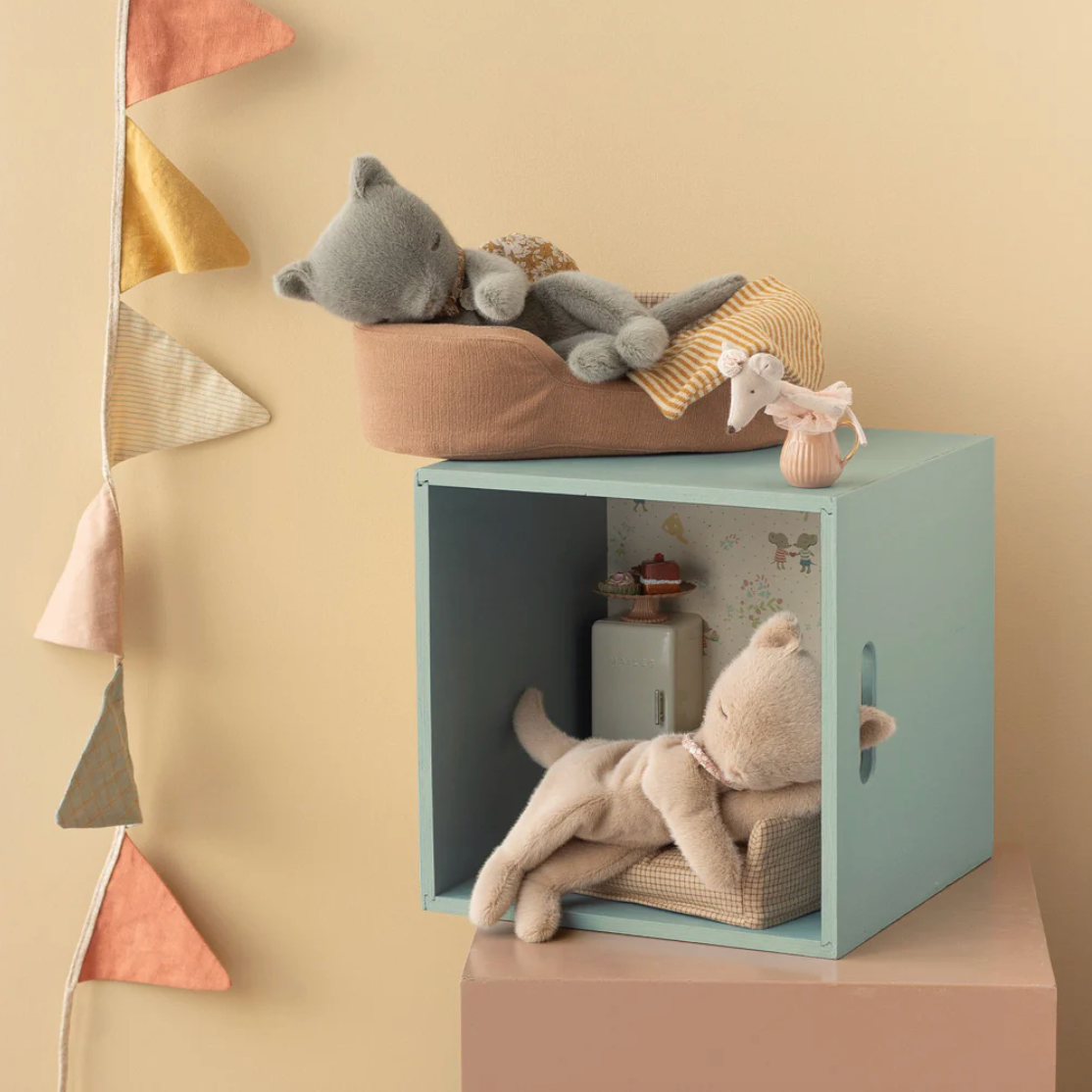 Children's toy storage cube with plush toys on a beige background