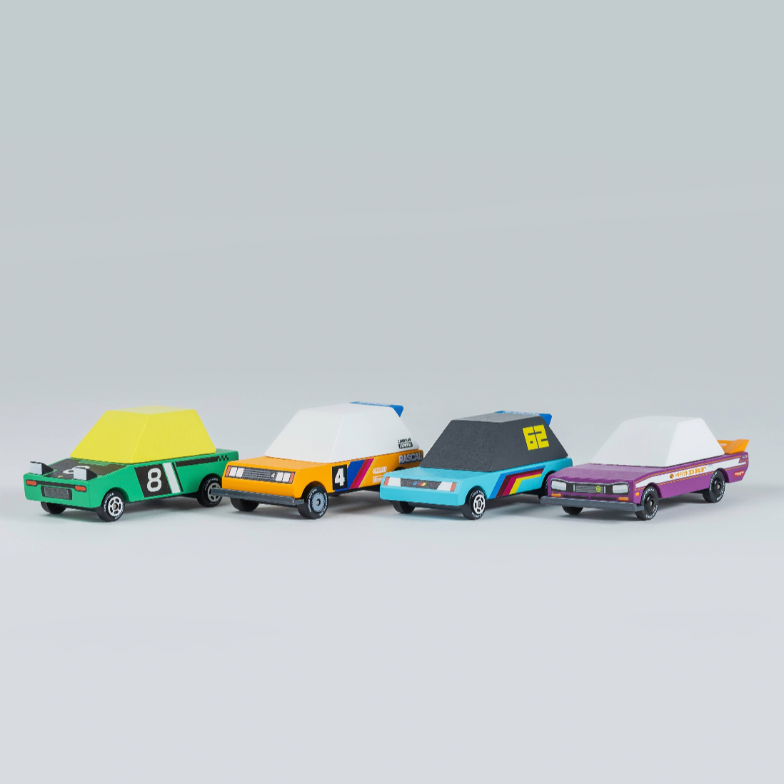 Four colorful toy cars on a gray background