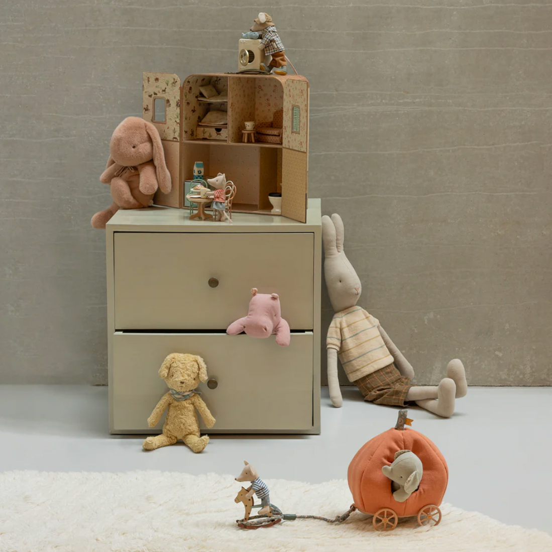 Children's room with a beige dresser, toys, and a toy horse on a light gray floor.
