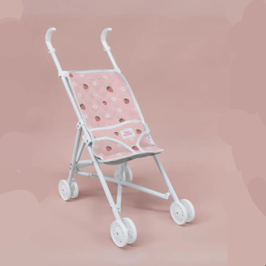 White baby stroller with pink canopy featuring strawberry pattern on a pink background