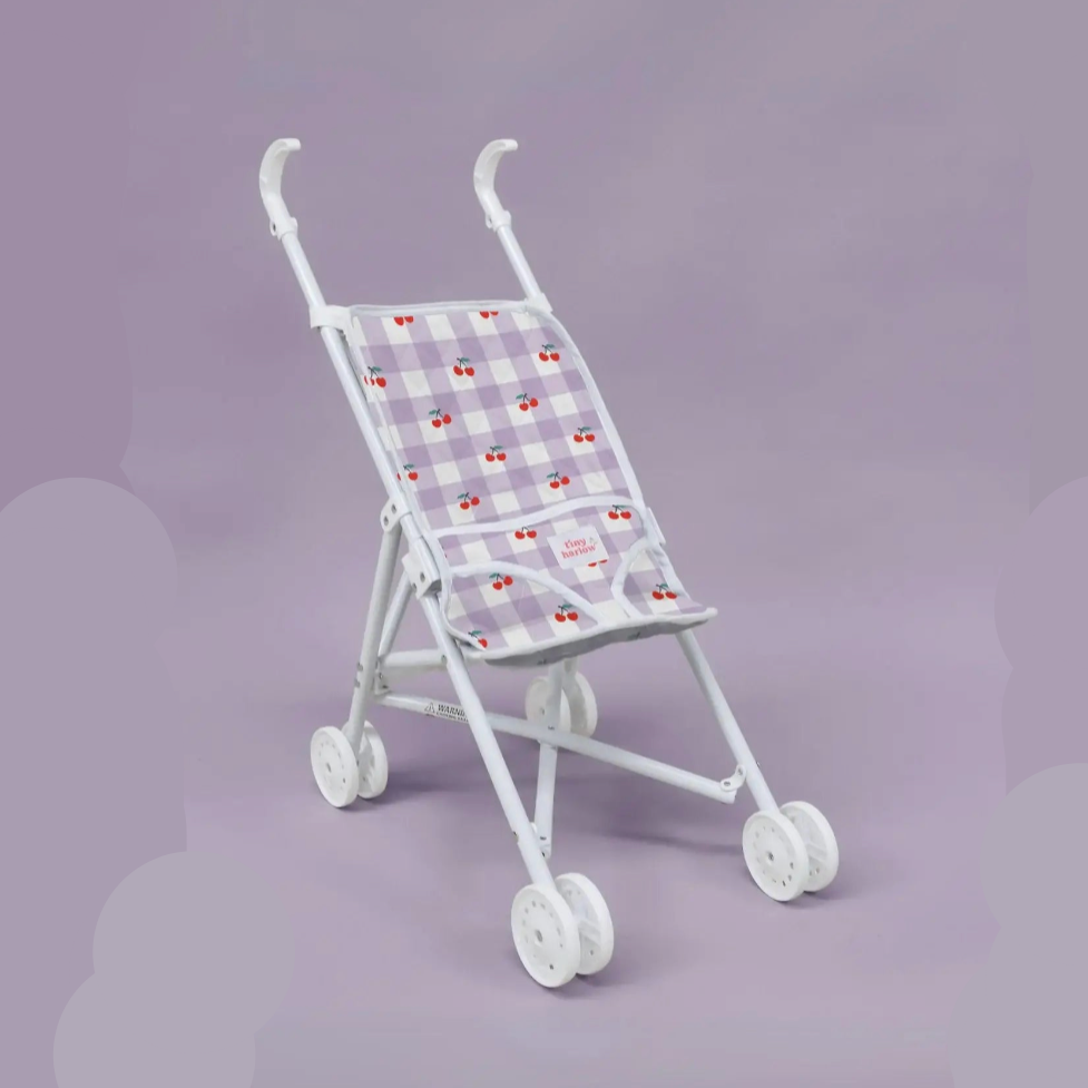 Small toy stroller with a checkered pattern on a purple background