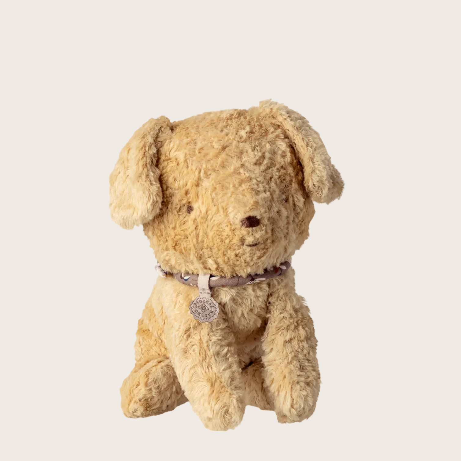 Beige teddy bear with a tag on a white background, featuring the Maileg logo.