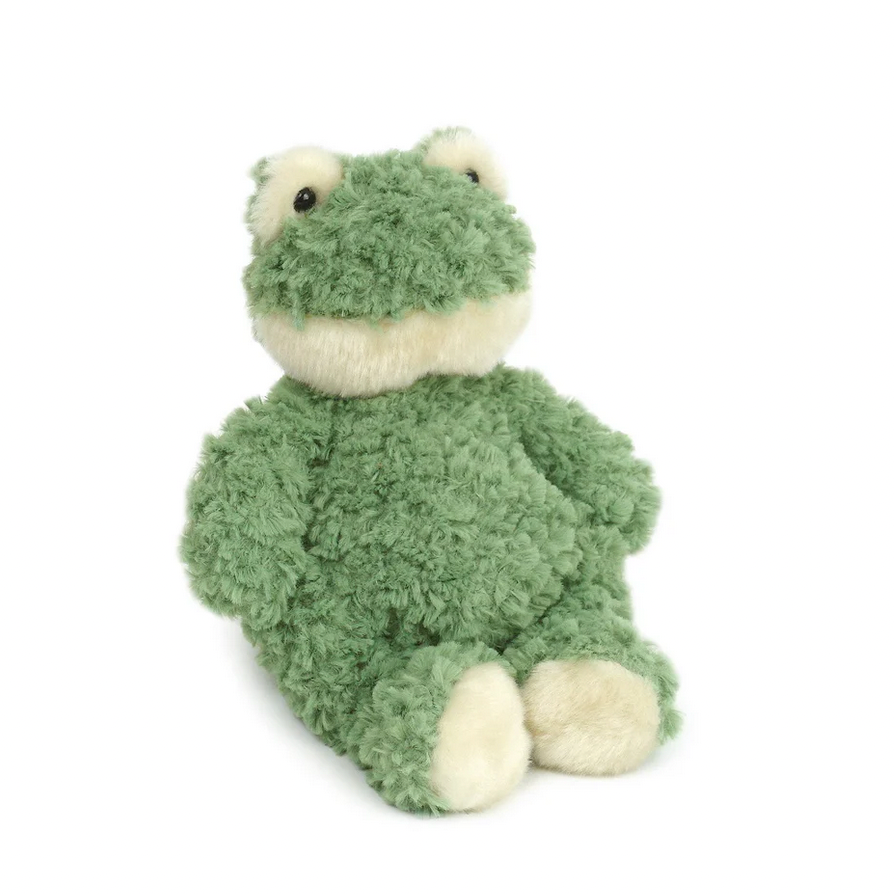Green plush frog toy on a white background with a black bag in the corner.