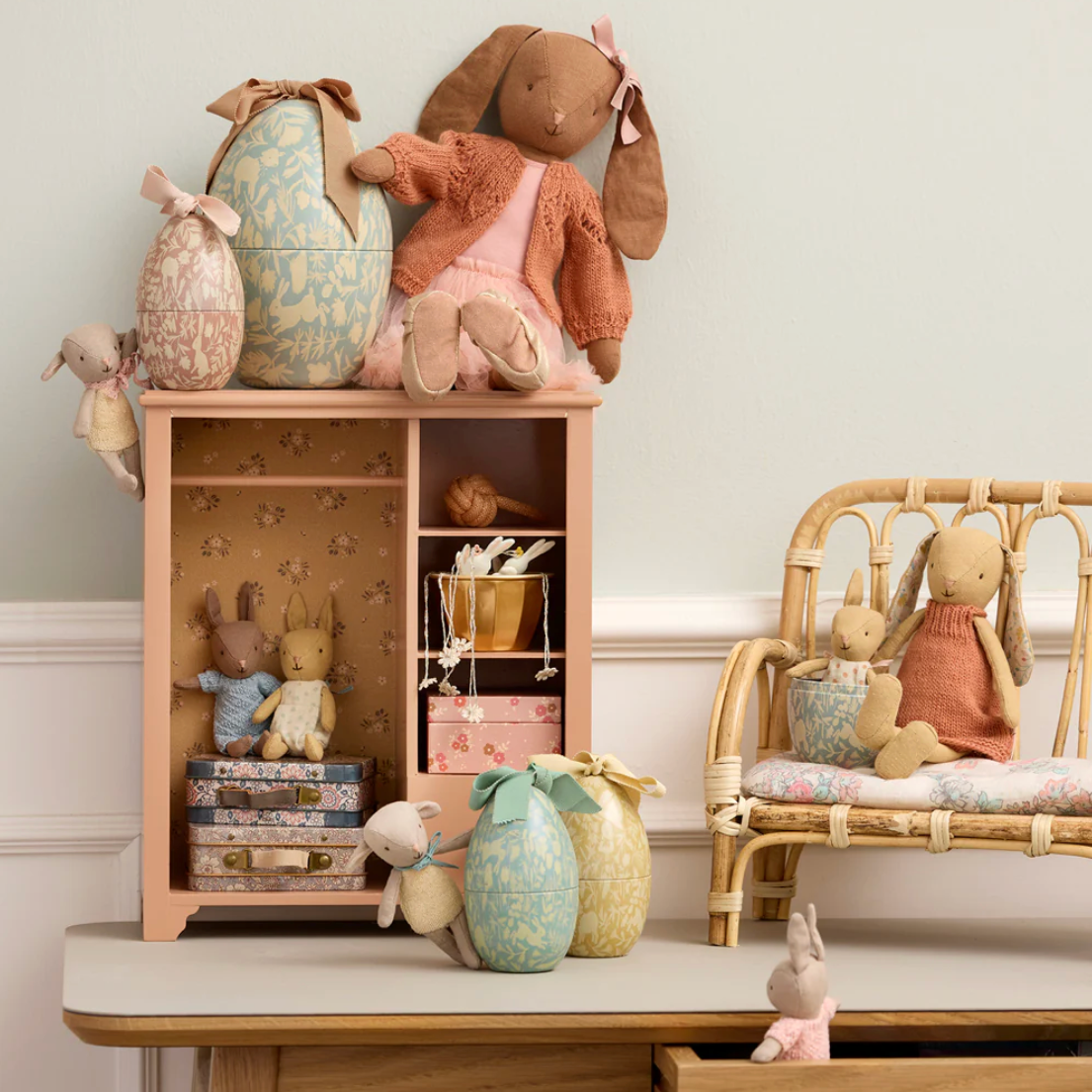 Children's room with wooden shelf and chair, filled with soft toys and decorative items.