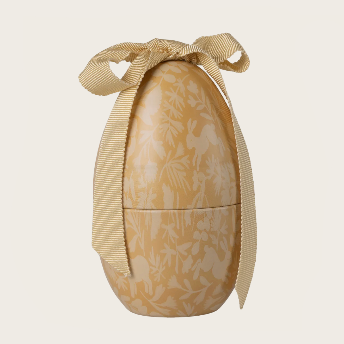 Decorative egg with a ribbon on a beige background