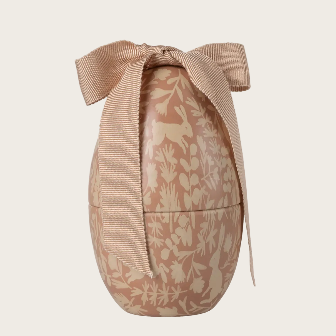 Decorative Easter egg with floral pattern and bow on a beige background