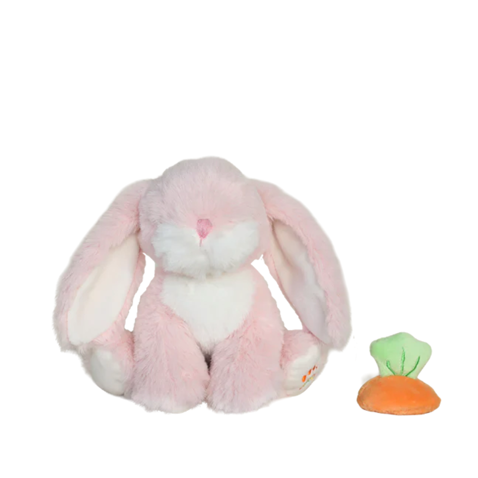 Pink plush bunny toy with a small carrot on a white background