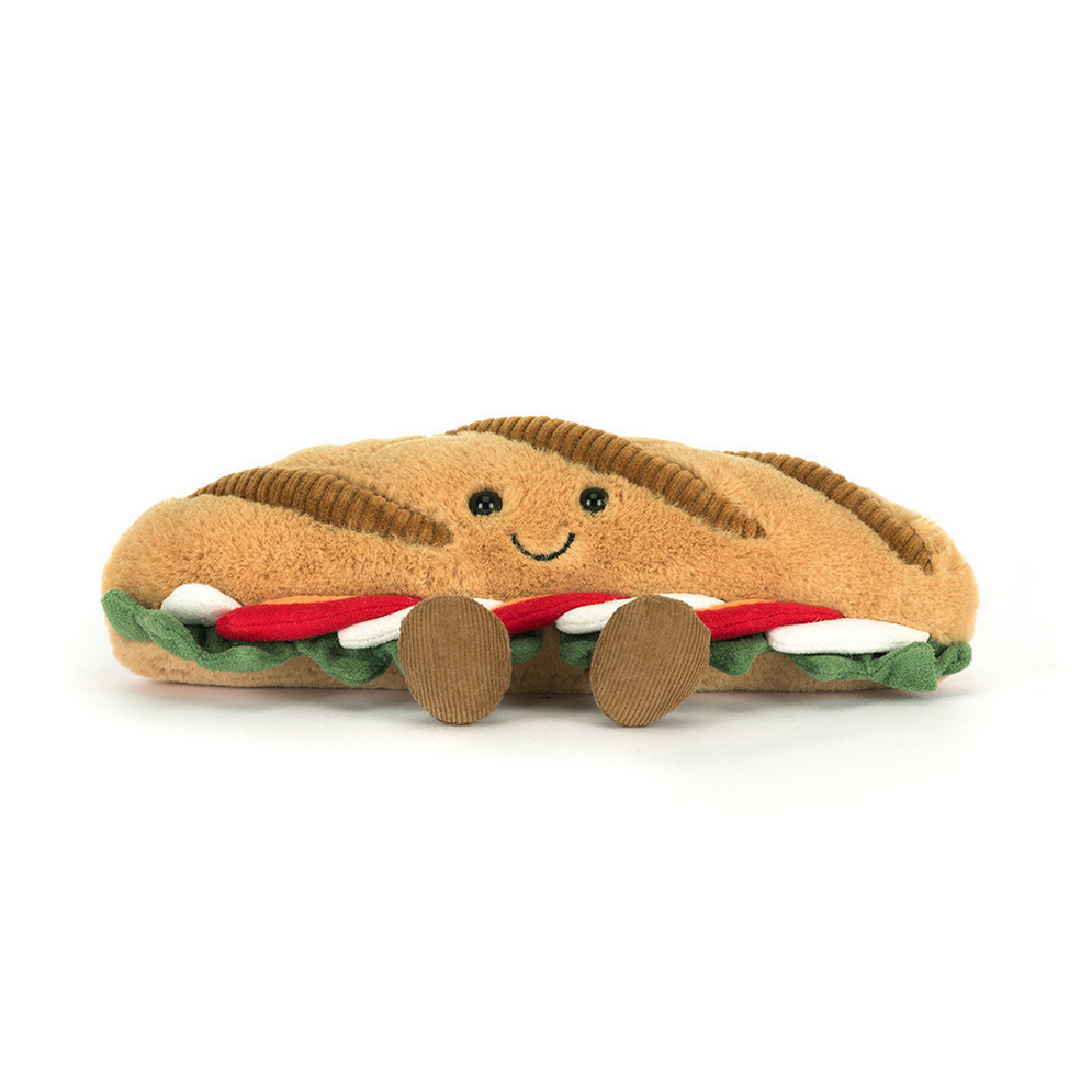 Plush toy shaped like a baguette with smiley face on a white background