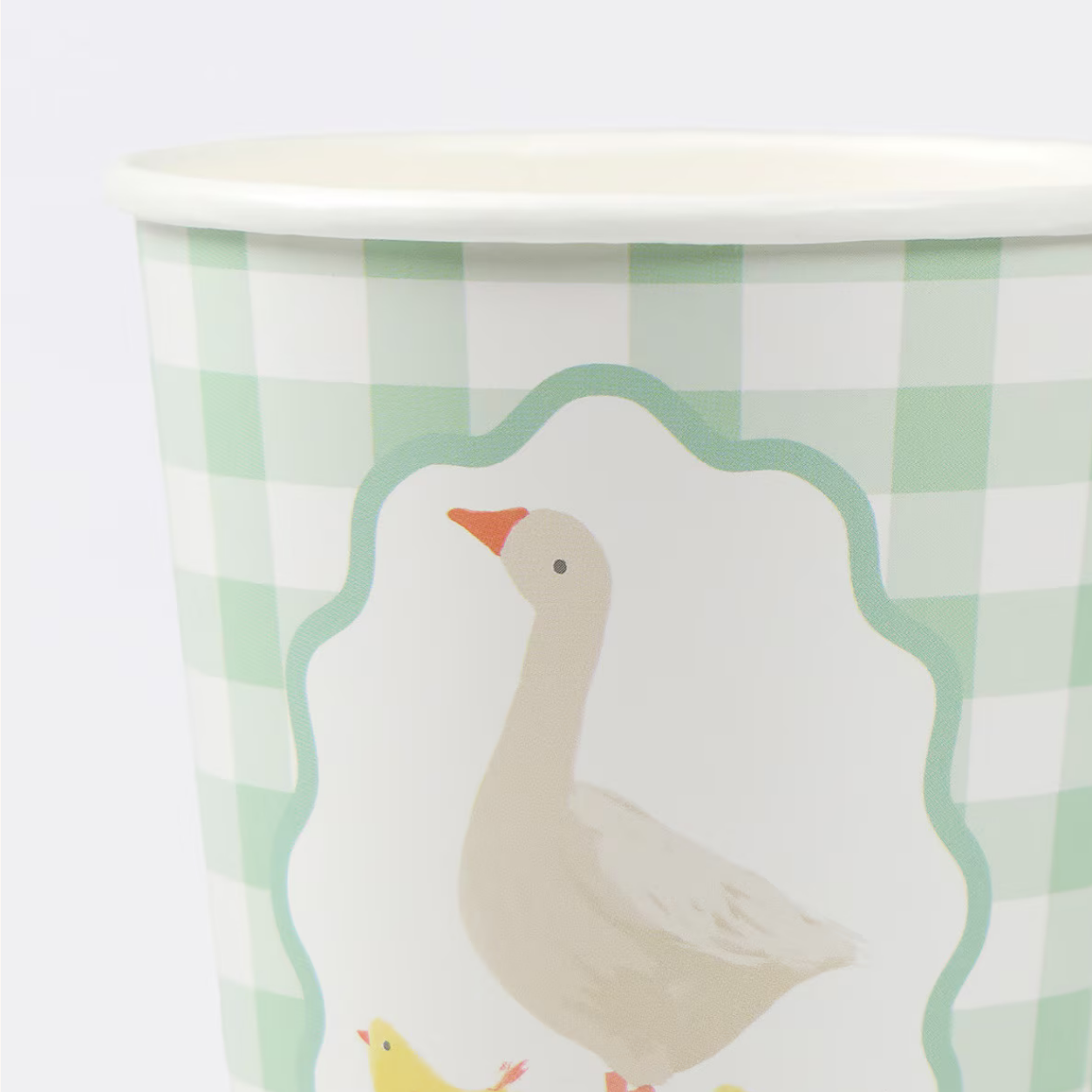Paper cup with a goose design on a green and white checkered background