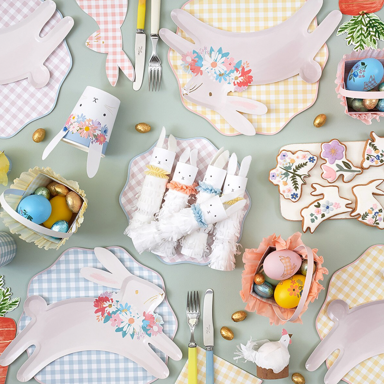 Easter-themed table setting with bunny-shaped placemats, cutlery, and decorative eggs on a checkered tablecloth.