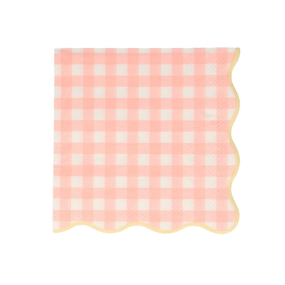 Pink and white checkered napkin with scalloped edge on a light pink background