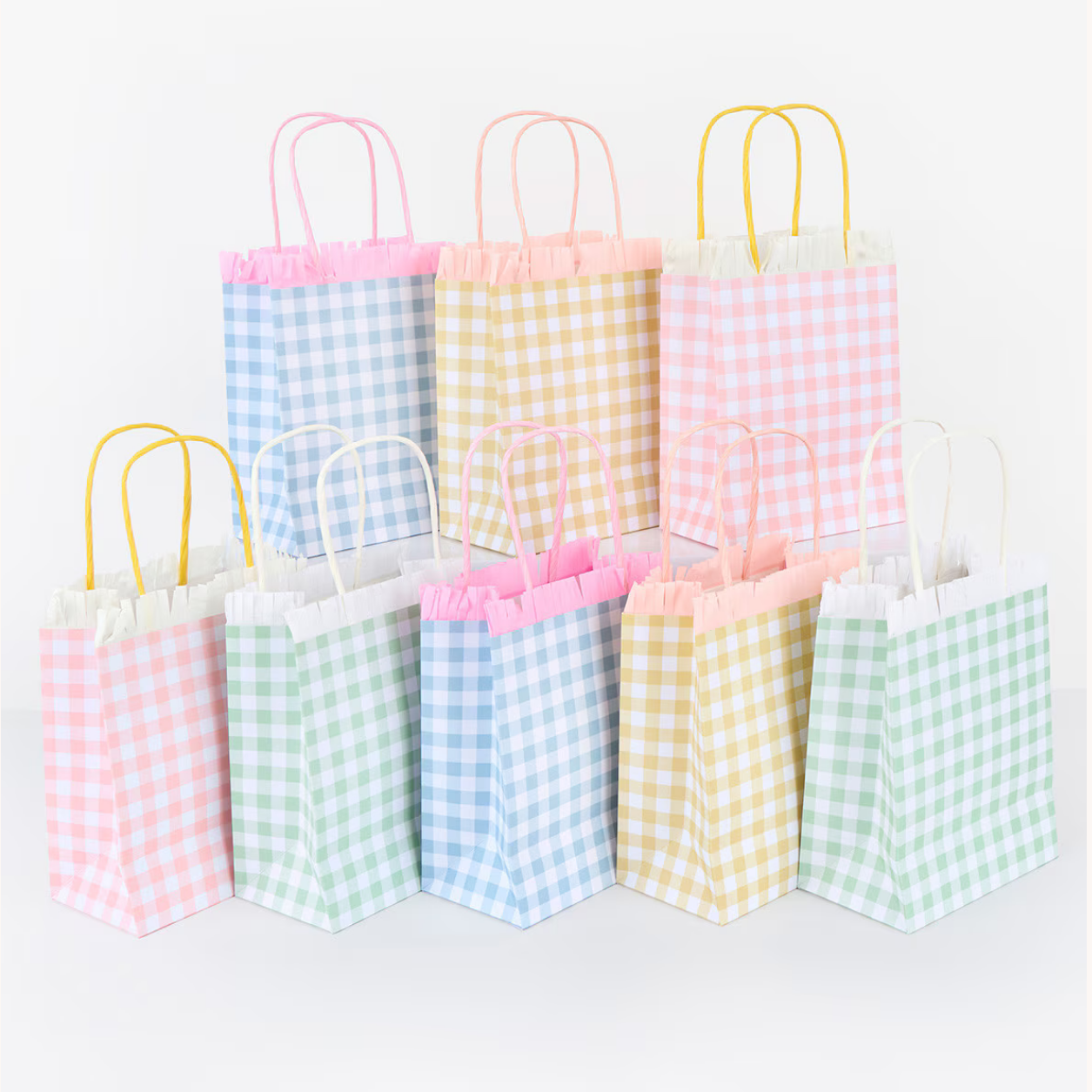 Set of small paper gift bags with checkered patterns on a white background