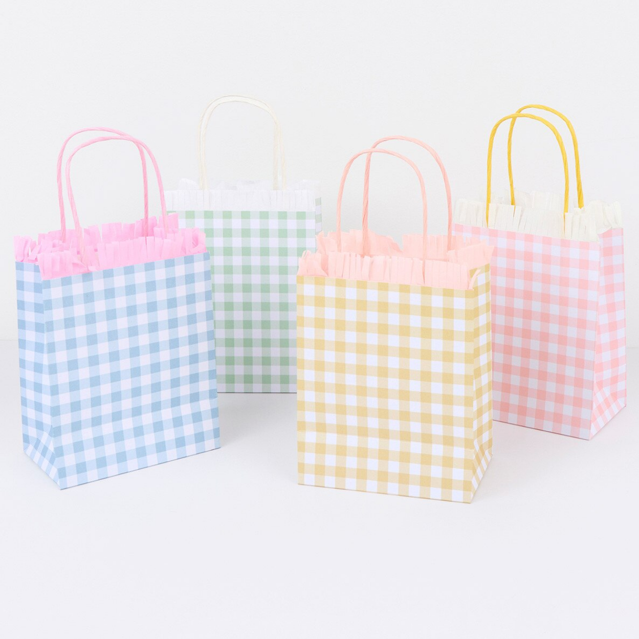 Four small paper gift bags with gingham patterns in pastel colors on a white background.