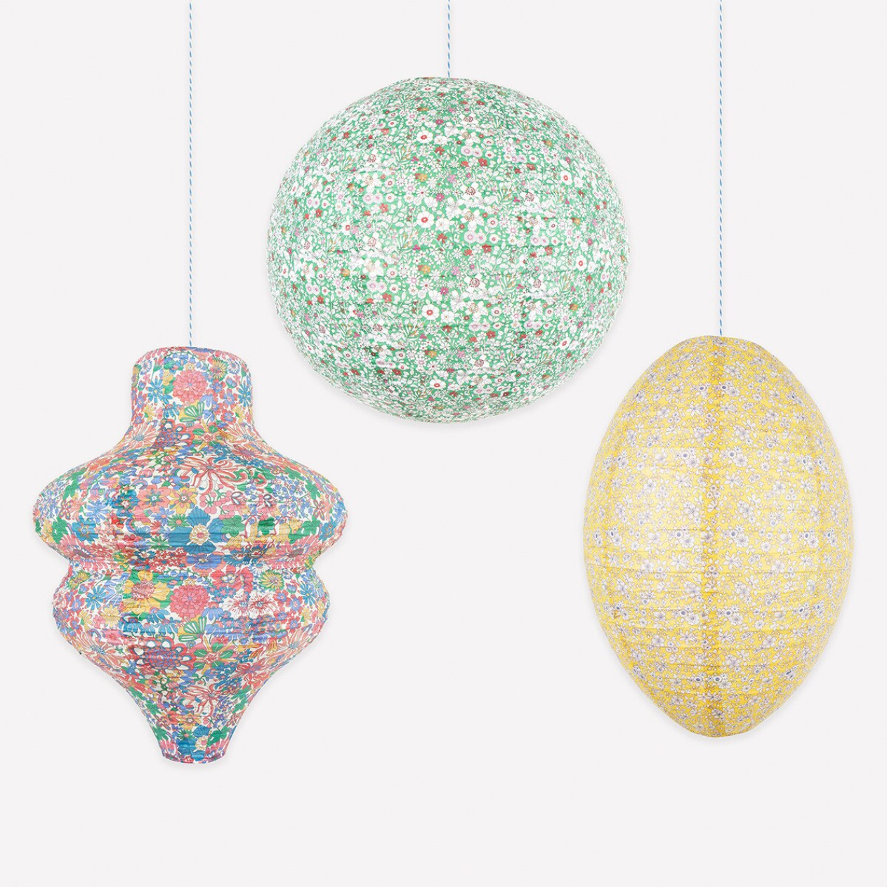 Three colorful ceramic ornaments hanging against a white background