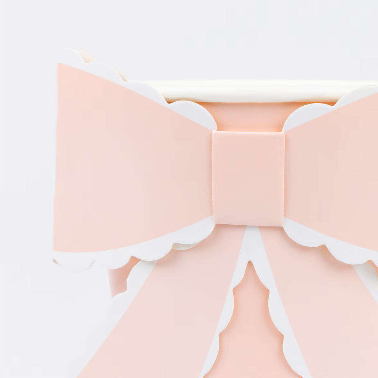 Large pink bow with white trim on a light gray background