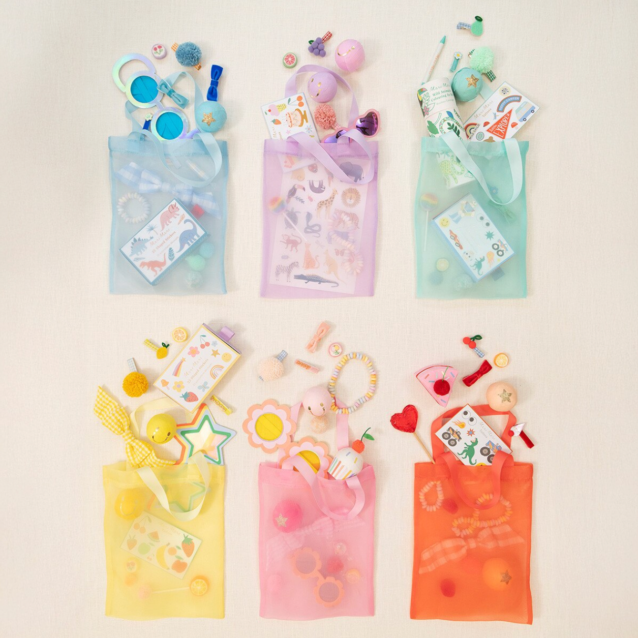 Colorful transparent bags with toys and stationery items on a light beige background