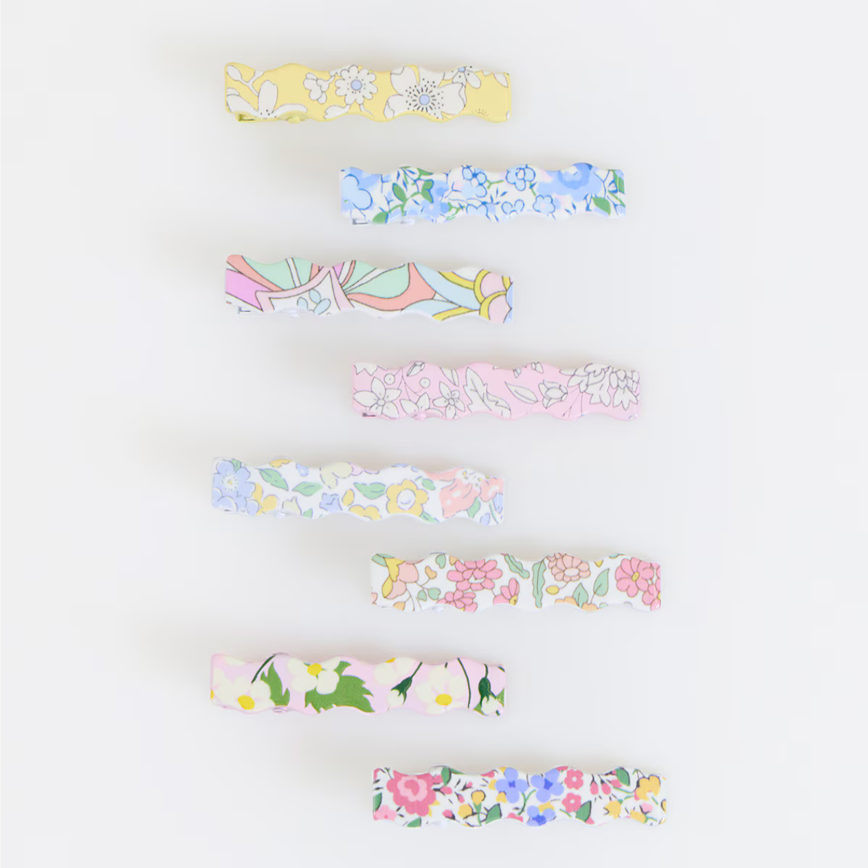 Set of colorful floral barettes on a white background