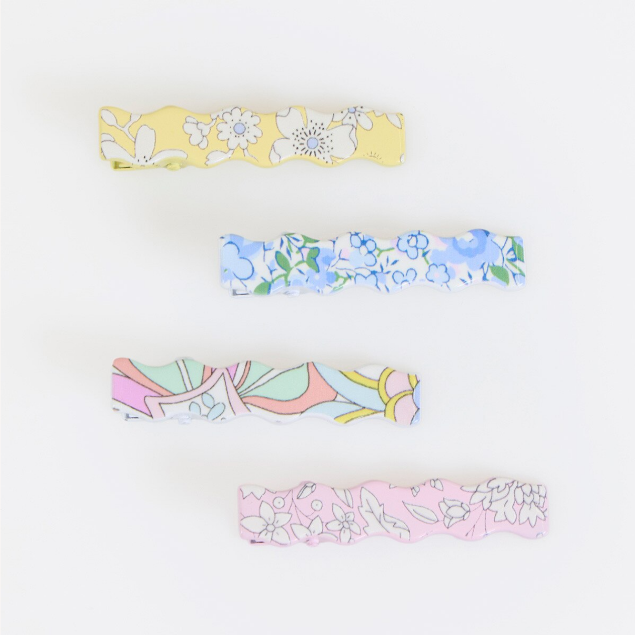 Set of four floral-patterned barettes on a white background