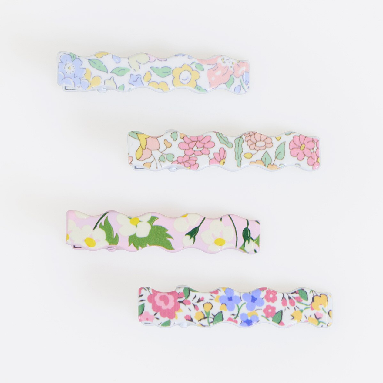 Four floral-patterned barettes on a white background