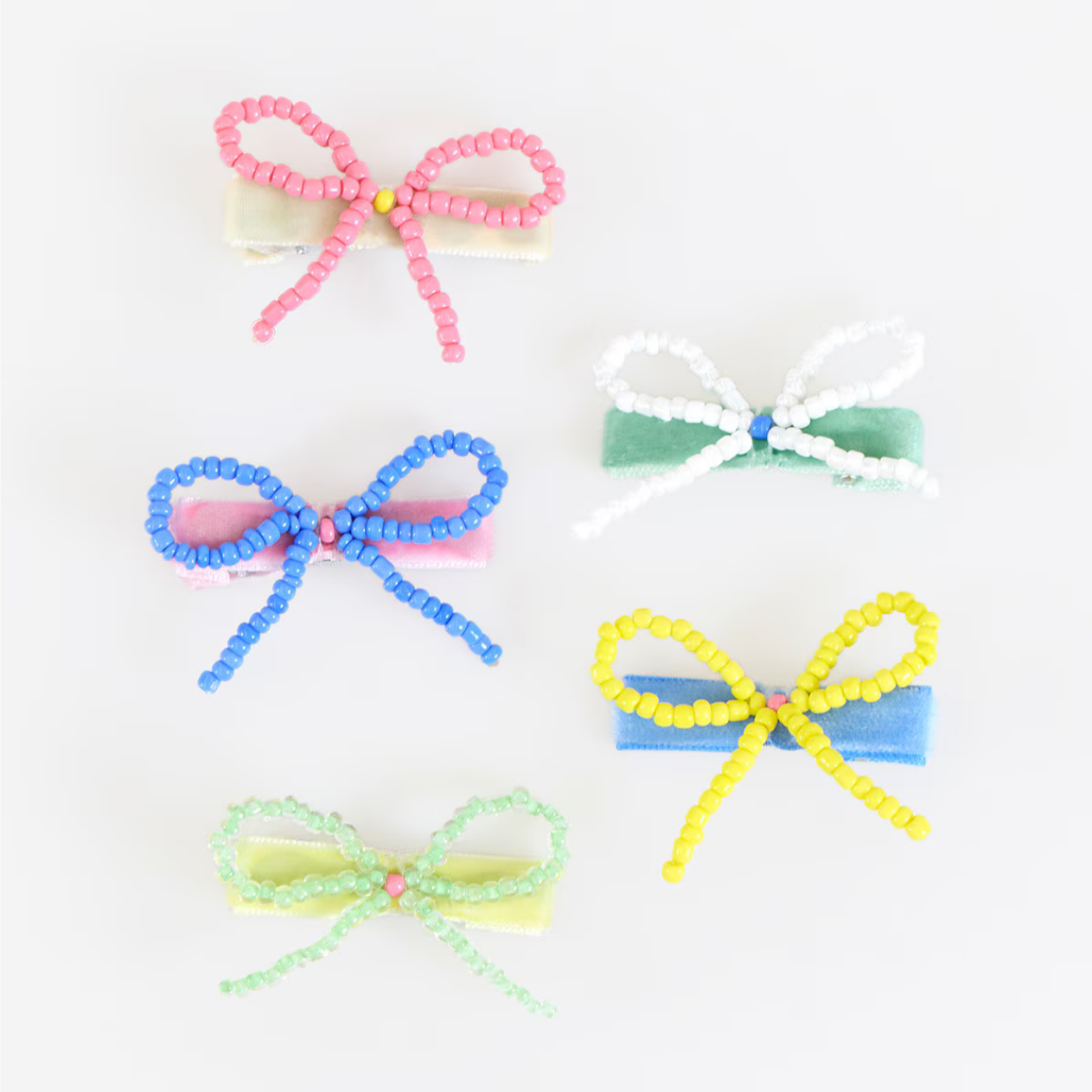 Five colorful beaded hair bows on a white background