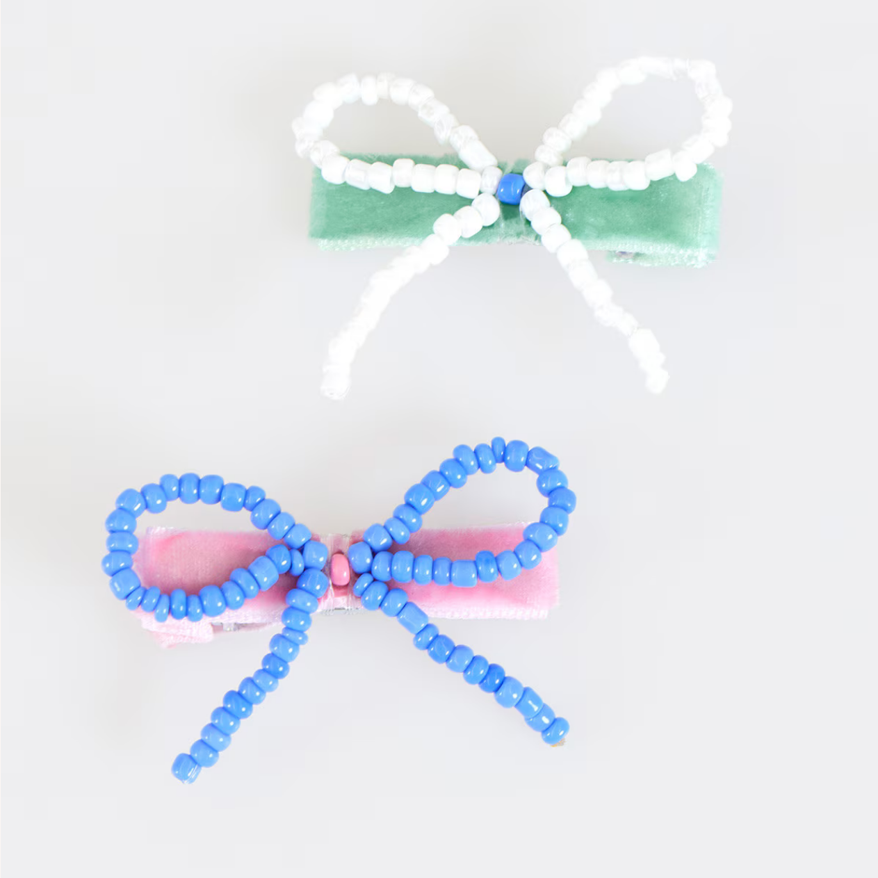 Two hair bows with colorful beads on a white background