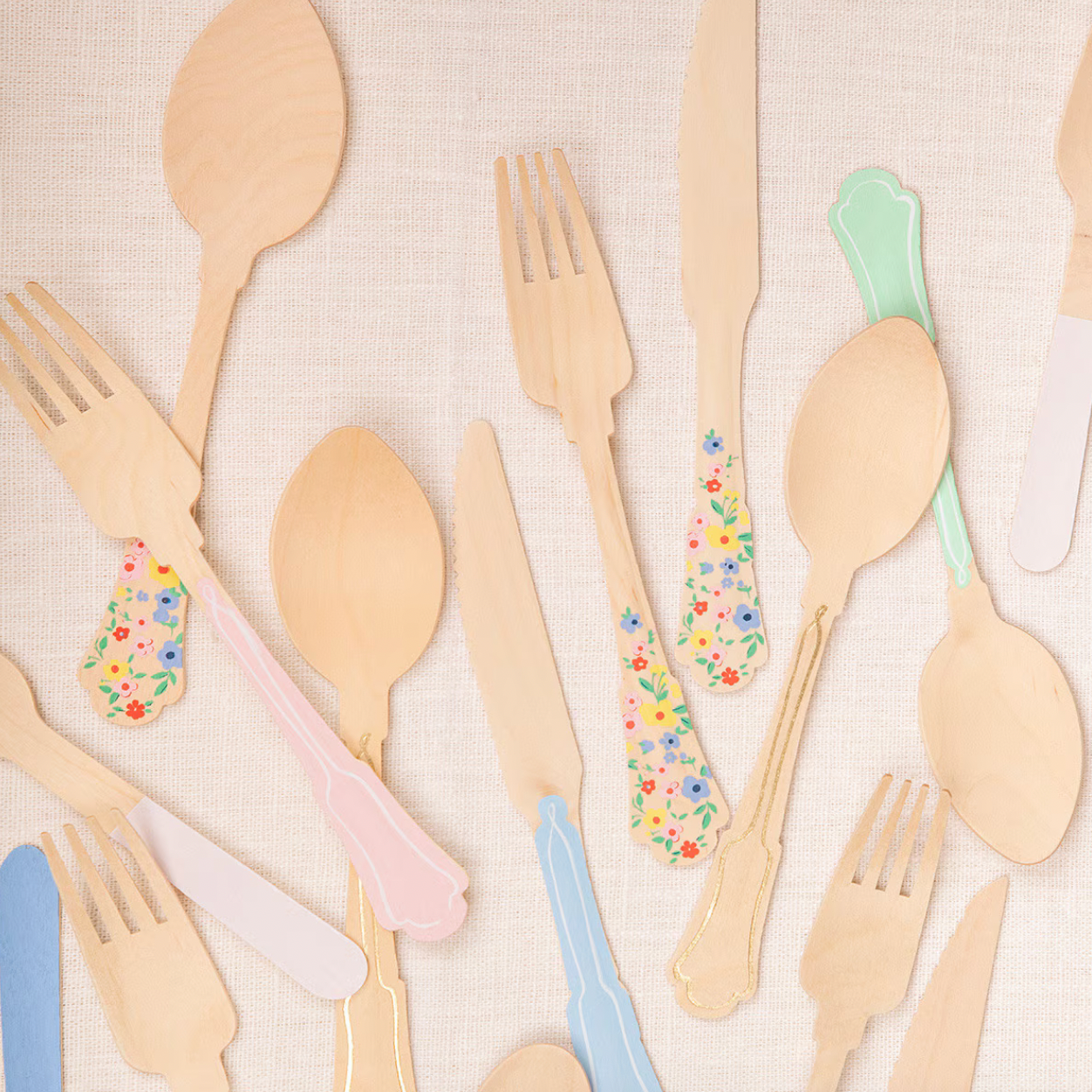 Set of wooden cutlery with floral decorations on a beige background
