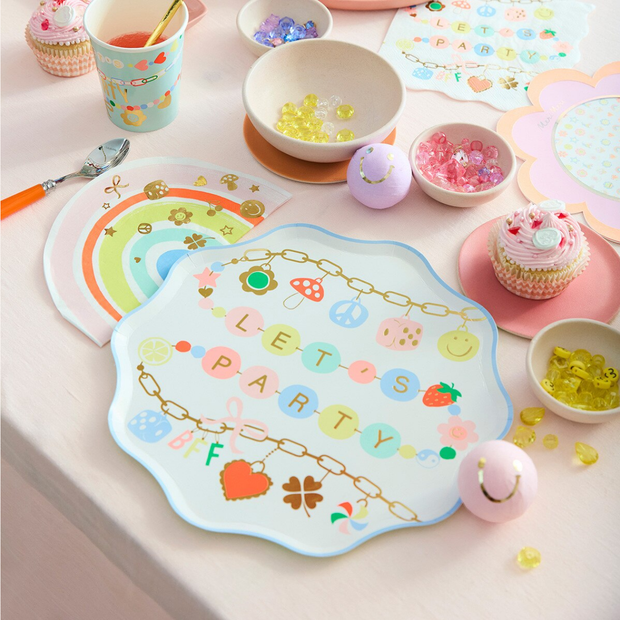 Decorative plate with 'Let's Party' text on a table with party supplies