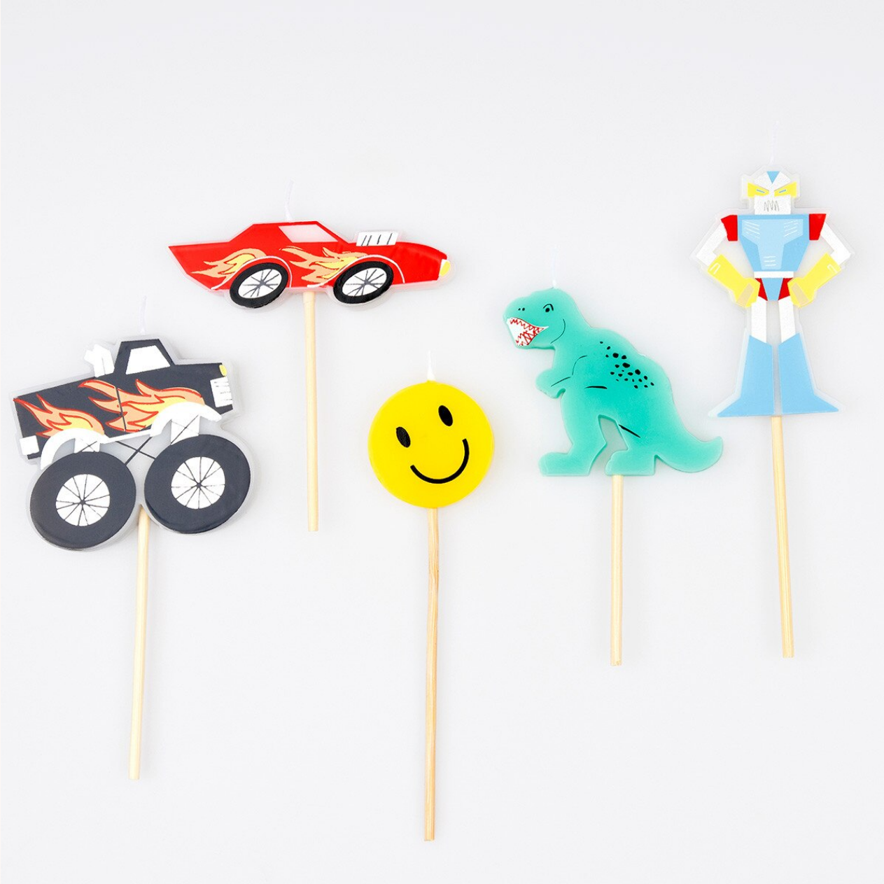 Set of colorful cupcake toppers on sticks with a car, monster truck, dinosaur, and smiley face design.