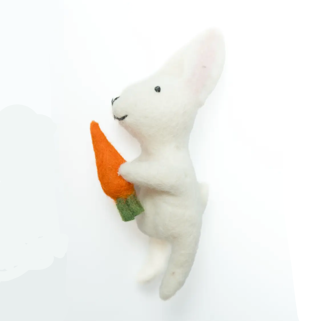 White plush toy resembling a bunny holding a carrot on a white background