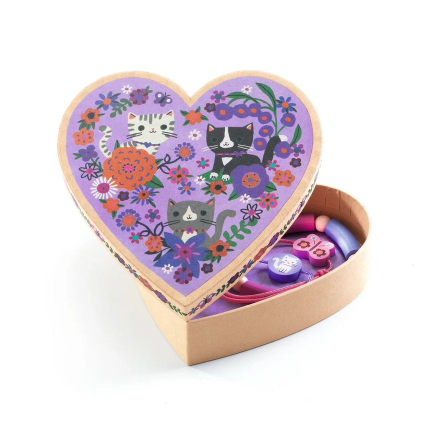 Heart-shaped toy box with cat and floral design on a white background