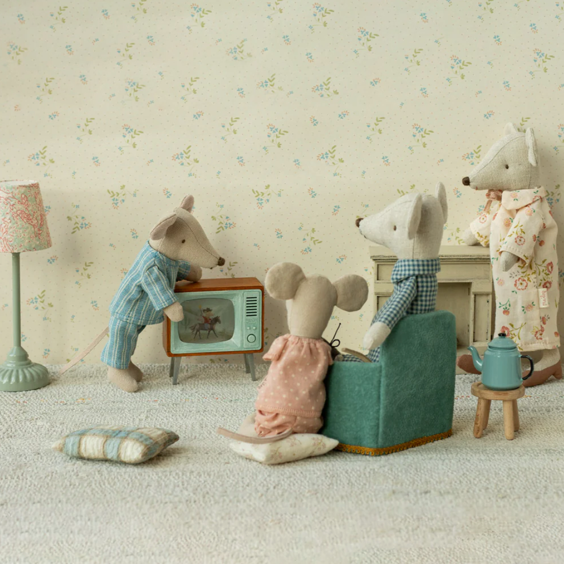 Toy animals in a living room setting with a floral wallpaper background