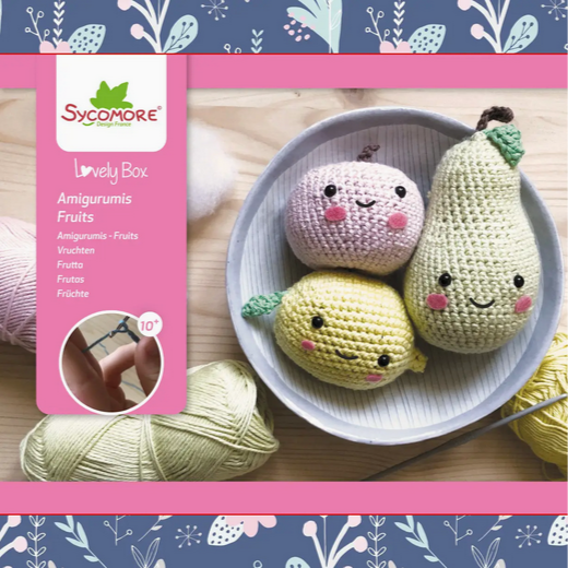 Crocheted fruits in a bowl with Sycomore packaging on a floral background