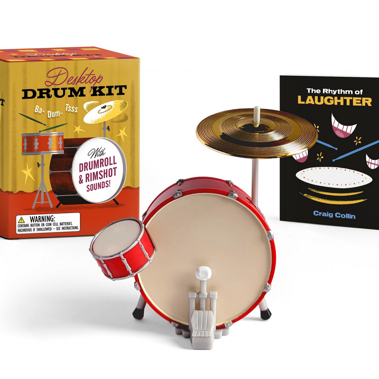 Miniature drum kit with packaging and a book titled 'The Rhythm of Laughter' on a white background.