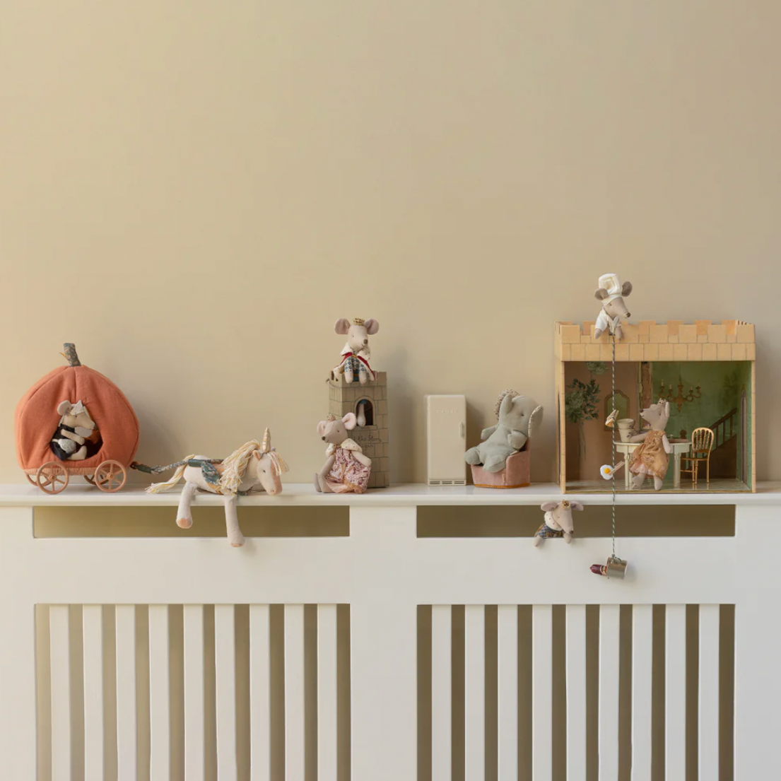 White cabinet with decorative items against a beige wall