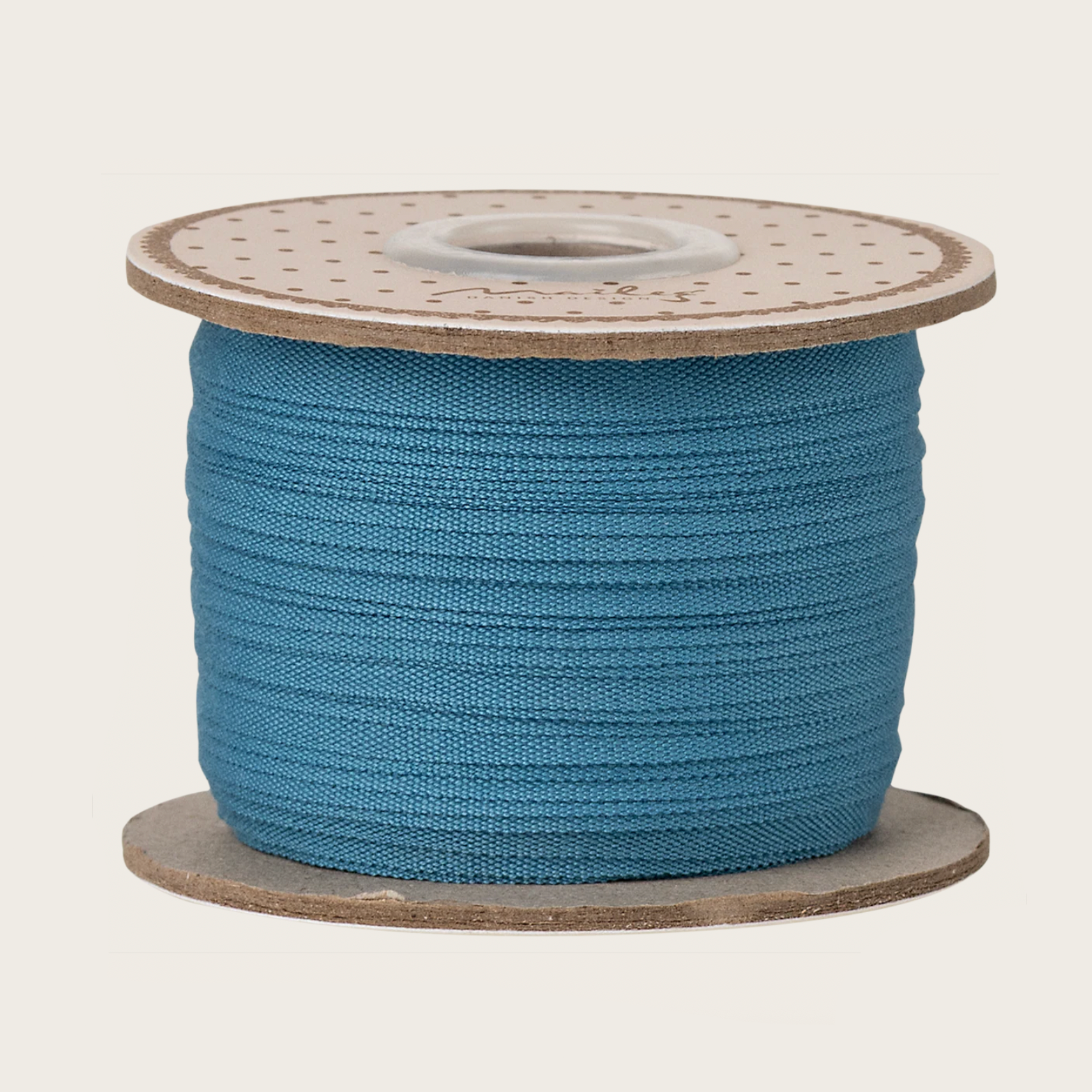Spool of blue ribbon on a white background with a computer screen in the background.