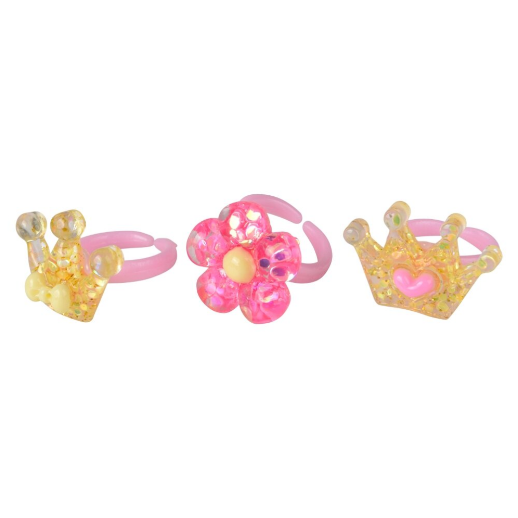 Three colorful children's rings with crowns and flowers on a white background