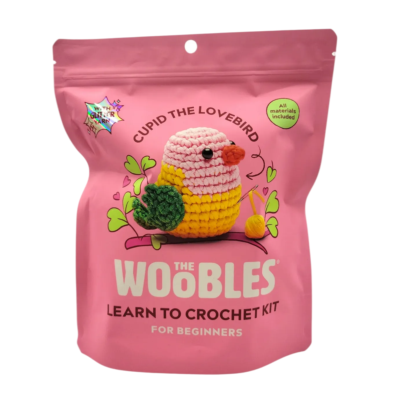 Pink crochet kit packaging for 'The Woobles' with a lovebird design on a white background.